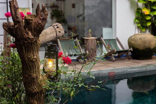 a lamp next to a tree next to a swimming pool at Hoi An Fairy Garden Villa in Hoi An