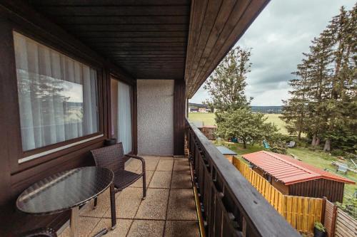 a balcony with a table and chairs and a view at Das Arni´s in Mehlmeisel