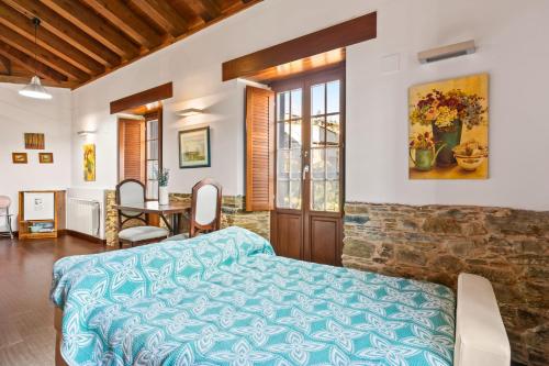a bedroom with a bed and a table with chairs at Mr de Alborada del eo in Villameitide