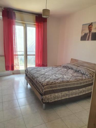 a bedroom with a bed and a window with red curtains at Dc apartment in Santa Maria Capua Vetere