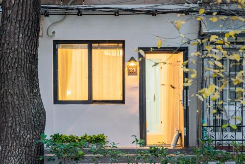 uma casa com duas janelas e uma porta em Tonight Homestay Jing'an Temple Shanghai em Xangai