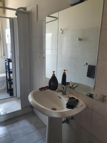 a white bathroom with a sink and a mirror at Dc apartment in Santa Maria Capua Vetere