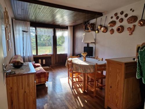 un salon avec une table et une cuisine dans l'établissement Grazioso appartamento vicino alle piste, à Montgenèvre