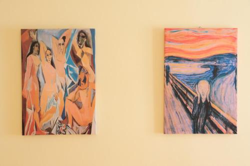 two paintings are hanging on a wall at The Maze Vibo B&B in Vibo Valentia
