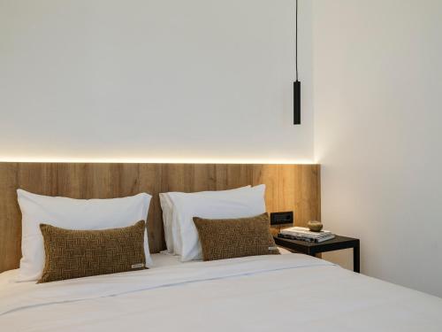 a bedroom with a bed with white sheets and pillows at Blue Eye Grand Villa Mykonos in Kalafatis