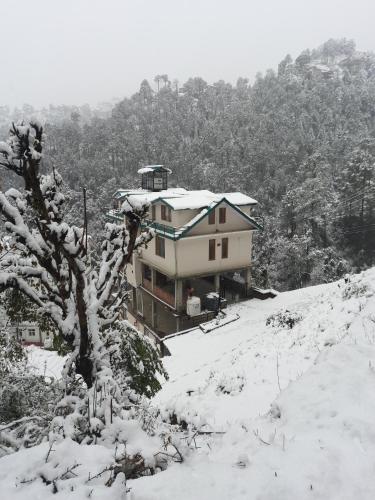 a house on top of a snow covered hill at Aagaman Woods in Shimla
