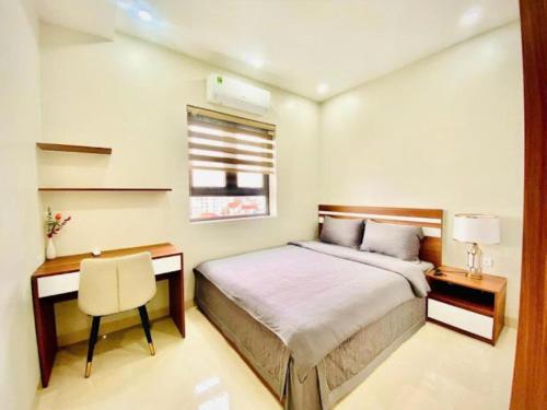 a bedroom with a bed and a desk and a chair at Phương Đông Hotel and Apartment in Hai Phong