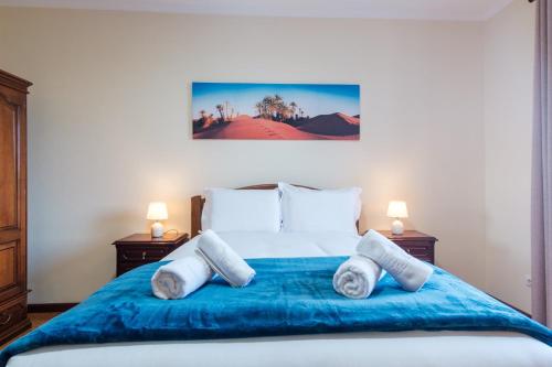 una camera da letto con un grande letto con lenzuola e cuscini blu di GuestReady - A charming experience in Madeira a Machico