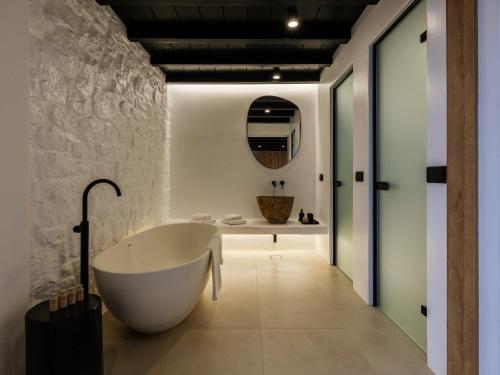 a bathroom with a white tub and a sink at Blue Eye Grand Villa Mykonos in Kalafatis