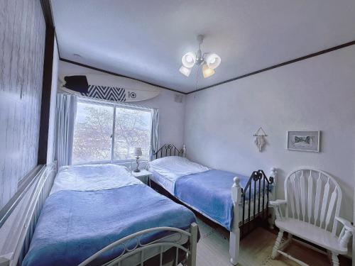two twin beds in a room with a window at 樽前の雪 in Otaru