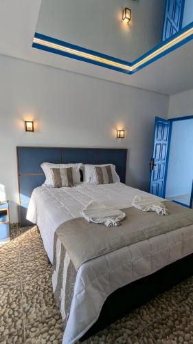 a bedroom with a large white bed with blue ceilings at Hotel Paraiso Maragogi LTDA in Maragogi