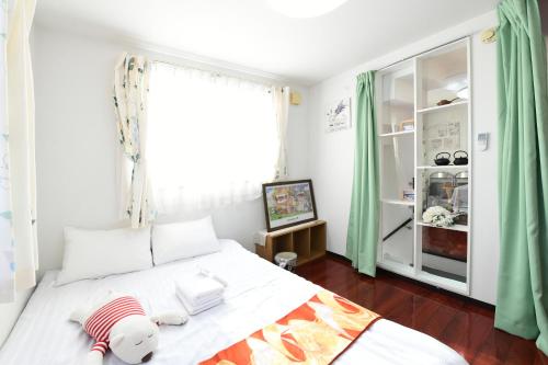 a bedroom with a bed with a teddy bear on it at JING HOUSE京成高砂駅5分豪華一戸建て最大8人成田羽田直通無料駐車浅草スカイツリー近くtokyo narita in Tokyo