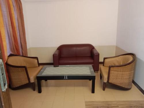 a living room with a couch and two chairs and a table at Arnala Beach Resort in Virār