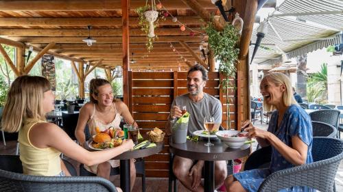 a group of people sitting around a table in a restaurant at Camping Les Palmiers in Hyères