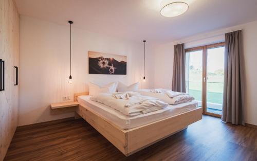 a bedroom with a bed and a large window at Benedikt & Wilhelmine in Rettenberg