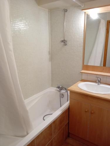 une salle de bain avec une baignoire et un lavabo dans l'établissement Terrasses D 308 PARC NAT VANOISE appart 4 pers, à Val Cenis
