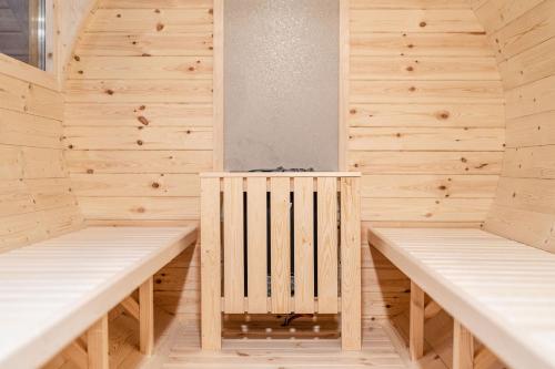 a sauna with wooden walls and two benches at Hotel garni Meledrio in Dimaro