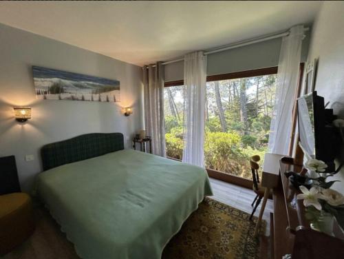 une chambre avec un lit et une grande fenêtre dans l'établissement VIlla MARGUERITE, à Lège-Cap-Ferret