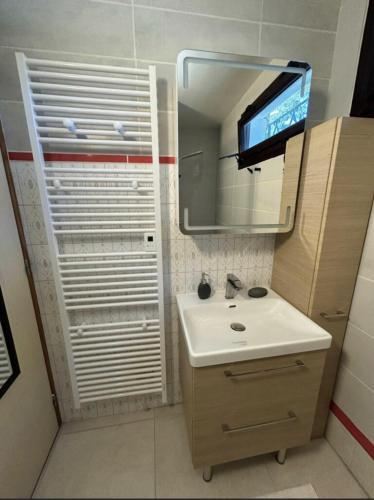 La salle de bains est pourvue d'un lavabo, d'un miroir et d'une télévision. dans l'établissement VIlla MARGUERITE, à Lège-Cap-Ferret