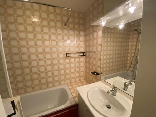 une salle de bain avec un lavabo et une baignoire dans l'établissement Appartement accès direct plage, à Arcachon