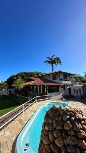ein Swimmingpool vor einem Haus in der Unterkunft Casarão 100 metros da praia in Barra de São Miguel