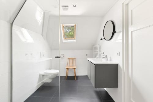 a bathroom with a sink toilet and a mirror at Zeayou Zeeland - Appartementen Markt 5 & 5a in Domburg
