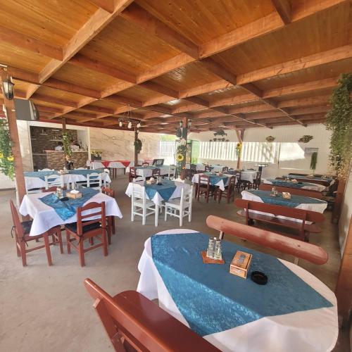 un restaurante con mesas y sillas azules en Vila Ayra, en Eforie Nord