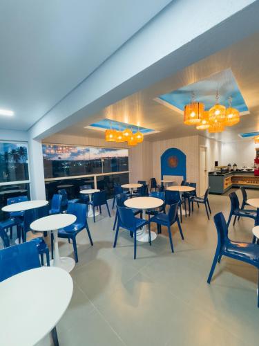 a dining room with tables and blue chairs at Hotel Paraiso Maragogi LTDA in Maragogi