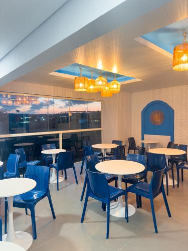 a dining room with tables and blue chairs at Hotel Paraiso Maragogi LTDA in Maragogi
