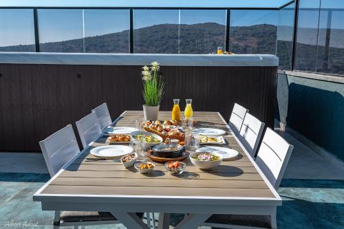 a table with food and drinks on a balcony at Naomi Boutique Suites in Netu'a