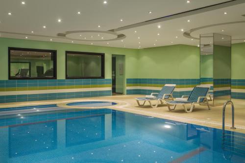 ein Pool in einem Hotel mit zwei Stühlen und einem Pool in der Unterkunft RAND by Wandalus in Riad