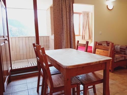 a dining room with a table and chairs and a window at Terrasses D 306 PARC NAT VANOISE appart 6 pers in Val Cenis
