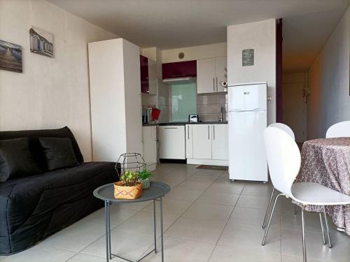 un salon avec un canapé et une table et une cuisine dans l'établissement Appartement T2 - 2 a 4 Personnes - Vue sur Mer - 4CAPE2N10, à Narbonne-Plage