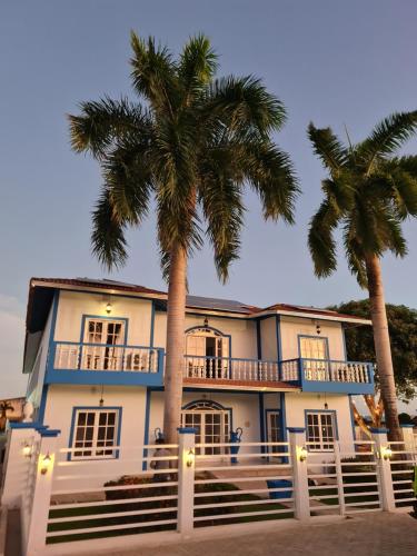 a house with two palm trees in front of it at Hotel Paraiso Maragogi LTDA in Maragogi