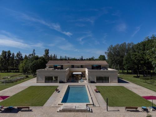 une grande maison avec une piscine devant dans l'établissement Domaine des Eucalyptus, à Mollégès