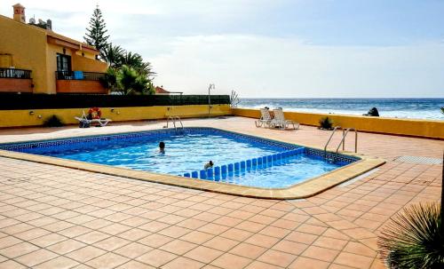 バジェ・グラン・レイにあるApartamento Alejandroの海のそばのスイミングプールでの2名