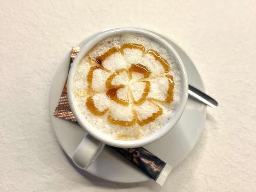 a cup of cappuccino with a face on it at Greet Hotel Brest Aéroport in Guipavas