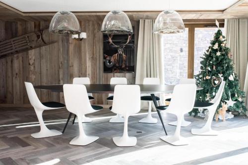 une salle à manger avec une table, des chaises et un arbre de Noël dans l'établissement L'Ours Rouge, à Les Allues
