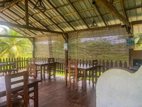 a restaurant with tables and chairs in a room at Lankapura Heritage in Sigiriya