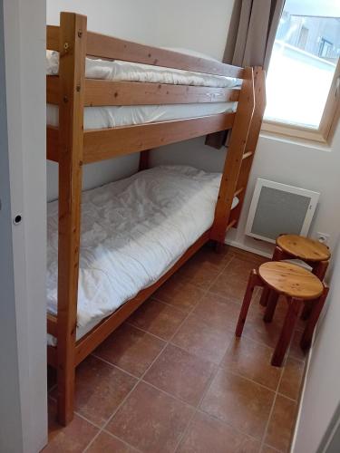 a couple of bunk beds in a room with a table at Terrasses E 305 PARC NAT VANOISE appart 6 pers in Val Cenis