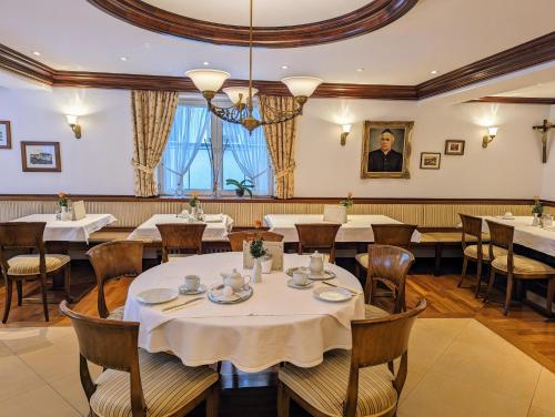 un comedor con mesas y sillas y un hombre en Hotel Germania, en Bad Wörishofen