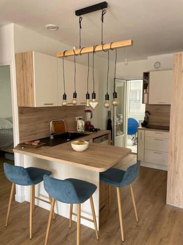 une cuisine avec une table en bois et des chaises bleues dans l'établissement Beautiful - Balcony - Close train and port, à Toulon