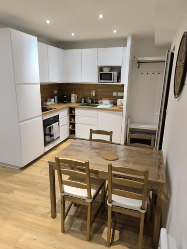 Il comprend une cuisine avec une table et des chaises en bois. dans l'établissement Sublime 3 p au centre-ville, à Saint-Martin-Vésubie