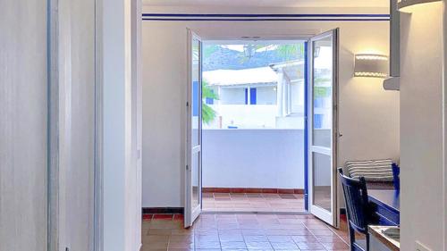 an open door to a patio with a table and a chair at Resort Cala La Luna in Favignana