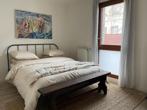 une chambre avec un lit et un tableau au mur dans l'établissement Colorful minimalist apartment 10min away from Paris, à Montreuil