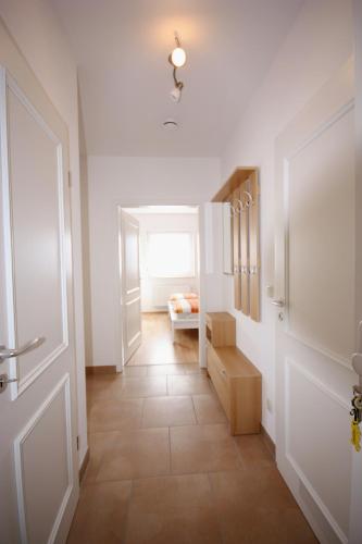 a hallway with a door and a room with a bed at Windjammer in Koserow