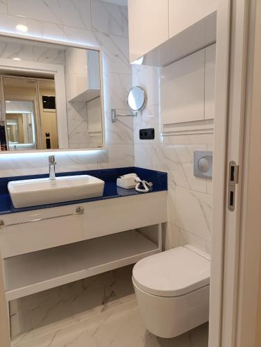 a bathroom with a sink and a toilet and a mirror at Orbi City D2 - Luxury Hotel - Sea View in Batumi
