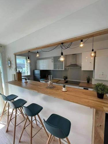 une cuisine avec un bar avec quatre chaises et un comptoir dans l'établissement Chic & Spacieux-Paris à porte-Au pied du Métro 14, à Saint-Ouen