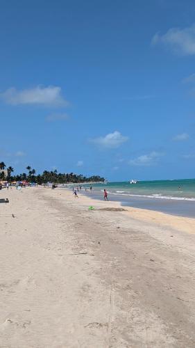 a group of people walking on the beach at Hotel Paraiso Maragogi LTDA in Maragogi