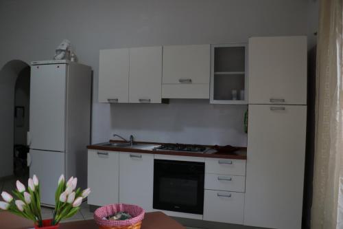 a kitchen with white cabinets and a refrigerator at The Maze Vibo B&B in Vibo Valentia